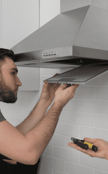 Range hood technician repairing a vent in Durango